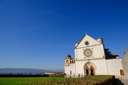 Assisi, Umbria, Italy. About october 2019. Church of San Francesco in Assisi with the stone wall. The basilica built in Gothic style houses the frescoes by Giotto and Cimabue.