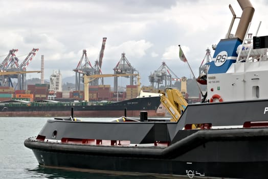 In the foreground, a tugboat used to tow the large ships in the harbor.