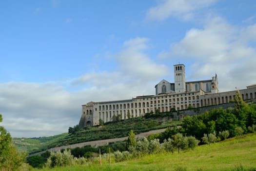 Convent and church of San Francesco in Assisi. The architecture immersed in the countryside with cultivation of olive trees.