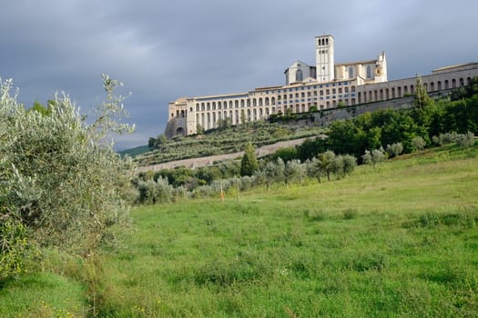 Convent and church of San Francesco in Assisi. The architecture immersed in the countryside with cultivation of olive trees.