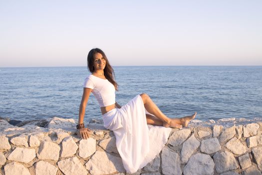 Woman in white dress on the beach with happy expression