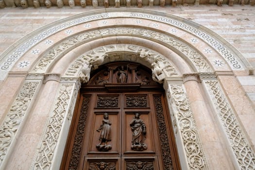 Foligno, Umbria, Italy. About october 2019.  Wooden door and portal in light marble carved of the Cathedral of San Feliciano in Foligno.