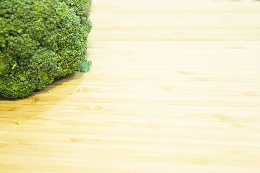 Raw broccoli on wooden cutting board. No people
