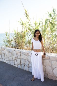 Portrait of young girl dressed in white with the sea in the background