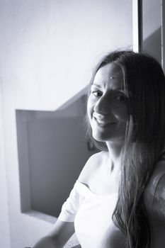 Portrait of young woman with enigmatic expression. Dark background