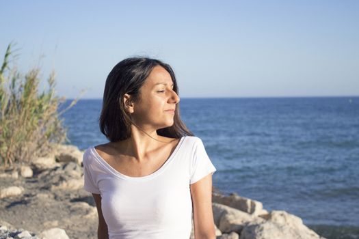 Portrait of young girl dressed in white with the sea in the background