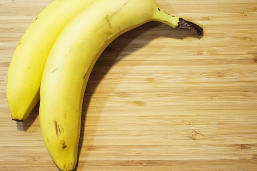 Various unpeeled bananas on wooden board. No people