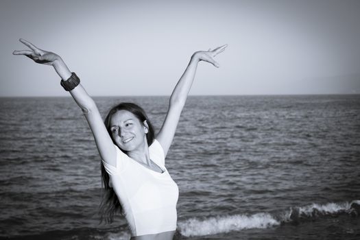 Attractive woman in white dress on the beach. Positive expression
