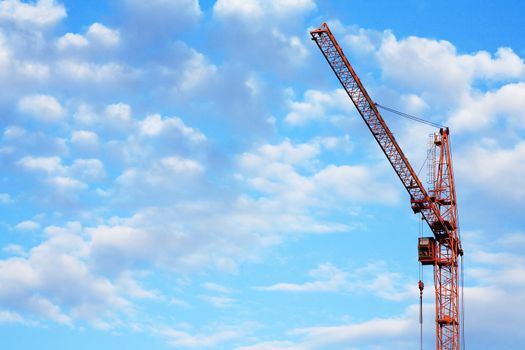 Industrial theme. Yellow construction crane against blue sky