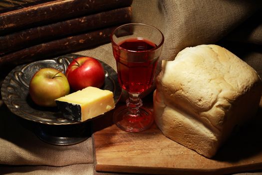 Loaf of white bread near cheese and fruits on canvas background