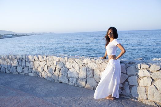 Woman in white dress on the beach with happy expression