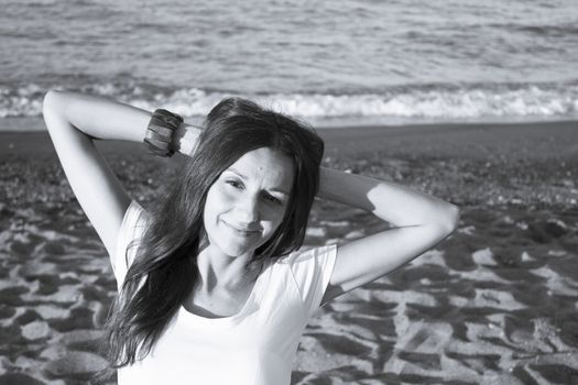 Girl with white t-shirt on the beach and her arms on the neck. Very happy