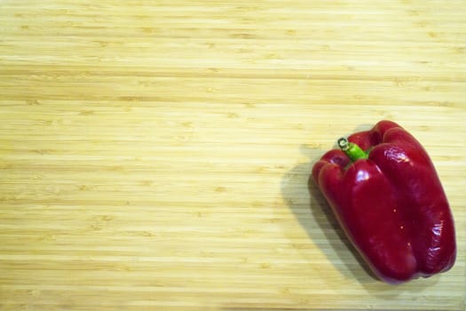 Raw ripe red pepper on cutting board. No people