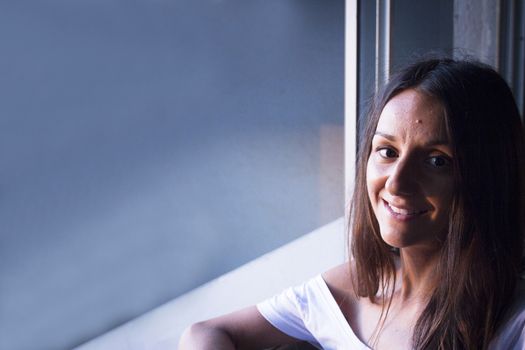 Portrait of young woman with enigmatic expression. Dark background