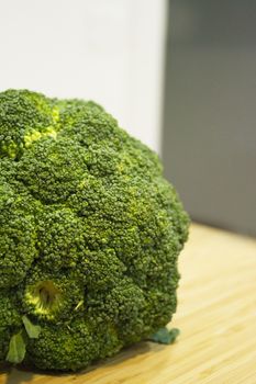 Raw broccoli on wooden cutting board. No people