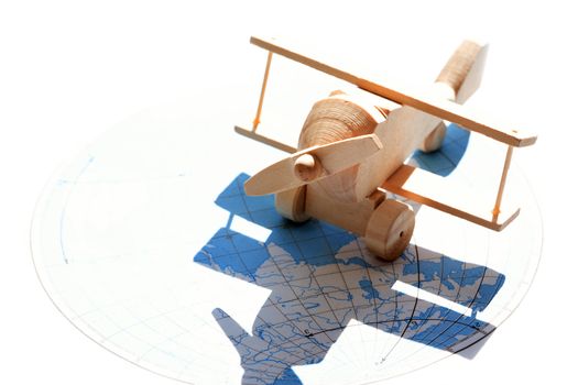 Travel concept. Small wooden airplane against sunlight with map as shadow
