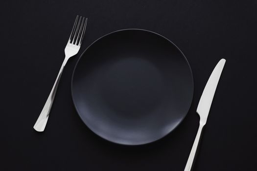 Empty plates and silverware on black background, premium tableware for holiday dinner, minimalistic design and diet concept