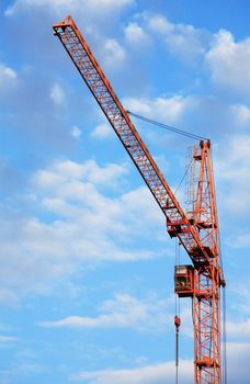 Industrial theme. Yellow construction crane against blue sky