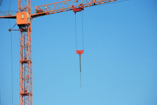 Industrial theme. Yellow construction crane against blue sky