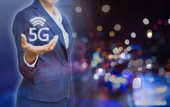 Business people showing 5g wireless and icon on city at the night time background