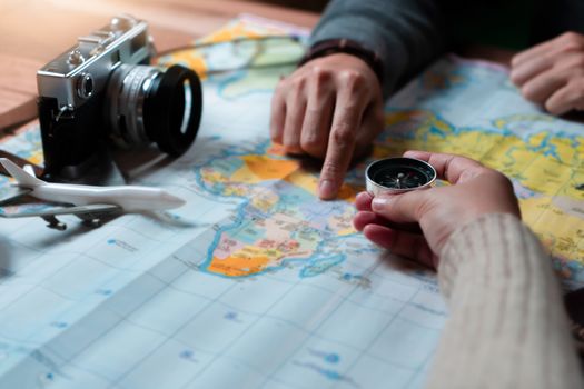 Woman with friend planning for vacation trip with accessories of traveler