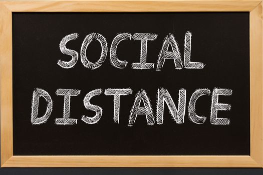 Social distance text on blackboard