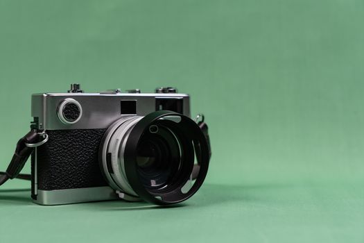 Retro camera with copy space on green background