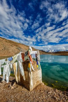 Small gompa with buddhist prayer flags at sacred Dhankar Lake in Himalayas. Spiti Valley, Himachal Pradesh, India