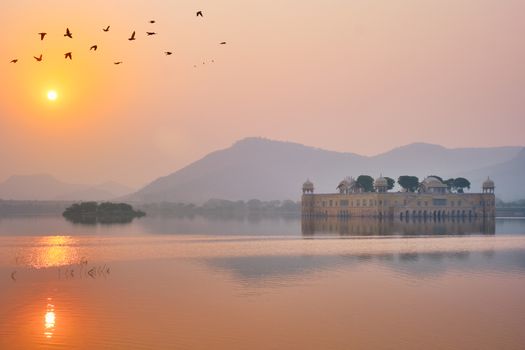 Tranquil morning at famous indian tourist landmark Jal Mahal (Water Palace) at sunrise in Jaipur. Ducks and birds around enjoy the serene morning. Jaipur, Rajasthan, India