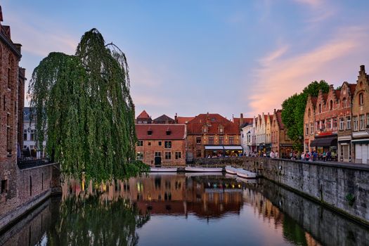 Bruges Rozenhoedkaai old houses along canal with tree in the evening. Famous place of Brugge, Belgium