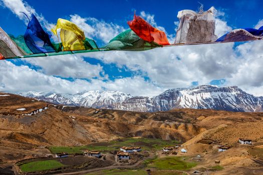 Buddhist prayer flags lungta with Om mani padme hum... mantra written on them in sky over Comic Village. Spiti Valley, Himachal Pradesh, India