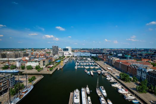 Yachts at the oldest harbor district of Antwerp city called Eilandje. Used as a yacht marina with waterfront promenade, Antwerp Province, Belgium