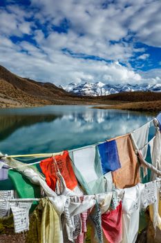 Prayer flags lungta with Om mani padme hum... mantra written on them and Dhankar Lake. Spiti Valley, Himachal Pradesh, India