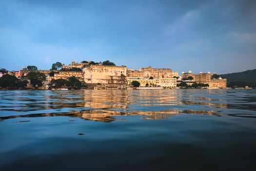 View of famous romantic luxury Rajasthan indian tourist landmark - Udaipur City Palace on sunset with cloudy sky - surface level view. Udaipur, Rajasthan, India