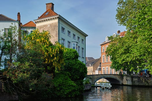 Bruges typical Belgian cityscape Europe tourism concept - canal and old houses and bridge. Brugge, Belgium