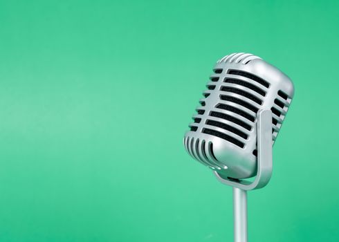 Retro microphone with copy space on green background