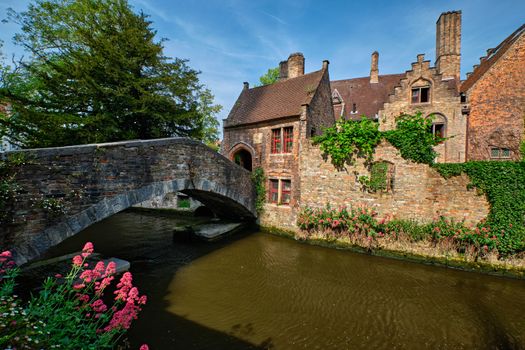 Old Bonifacius Bridge over Brugge canal and medieval houses with flowers in Bruges, Belgium