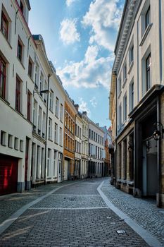 Antwerp cobblestone street with alley row of medieval houses at the old European city port, Belgium. Flanders