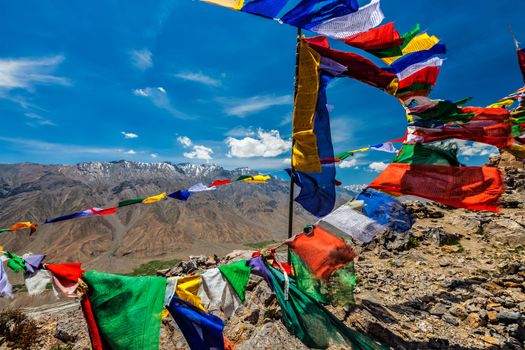 Buddhist prayer flags lungta with Om mani padme hum... mantra written on them in Spiti Valley in Himalayas, Himachal Pradesh, India