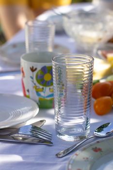 Set table in nature. White tablecloth.Outdoor spring or summer casual garden party set up for lunch dinner.