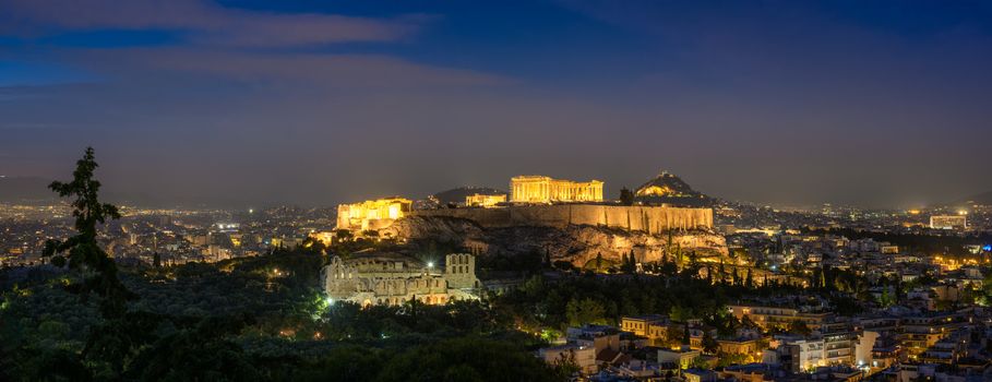 Panorama of Parthenon Temple and Amphiteater are iconic greek tourist landmark at Acropolis of Athens and ancient European civilization architecture. View from Philopappos Hill at night. Greece