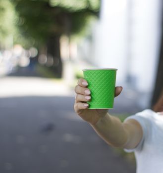 Mock up of cup coffee in woman's hand bright background for break, energy and strength, hot drink in paper cup. Tea or lemonade with ice, drink for business woman