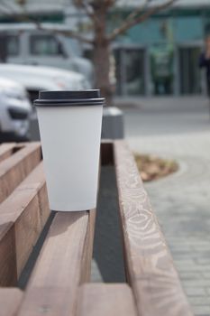 Breakfast and coffee theme: white paper coffee Cup with black plastic lid, outside. Coffee advertising