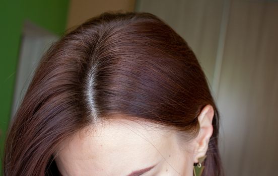 hair on a woman's head close-up. Hair brown color of