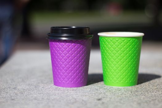 purple and green paper coffee Cup on the stove