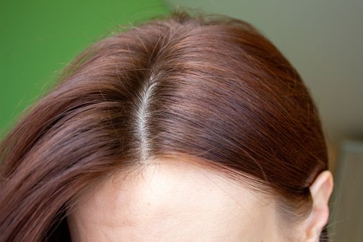 hair on a woman's head close-up. Hair brown color of