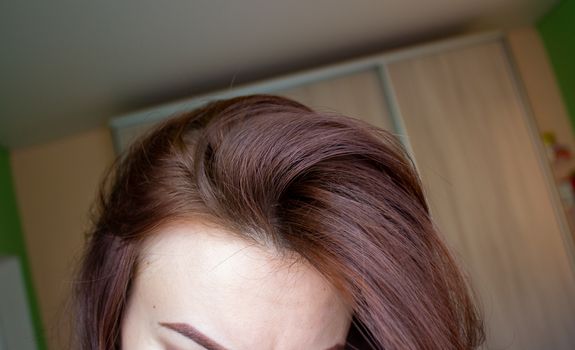 hair on a woman's head close-up. Hair brown color of