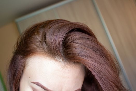 hair on a woman's head close-up. Hair brown color of