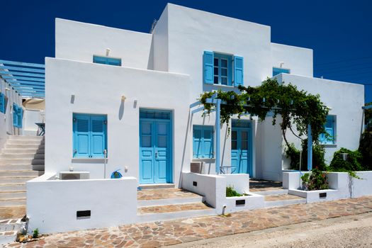 Traditional greek architecture - houses painted white with blue doors and window shutters. Pachena village, Milos island, Greece