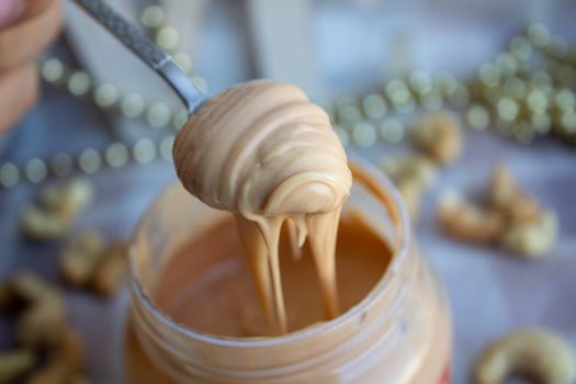 Creamy peanut butter and spoon on background.